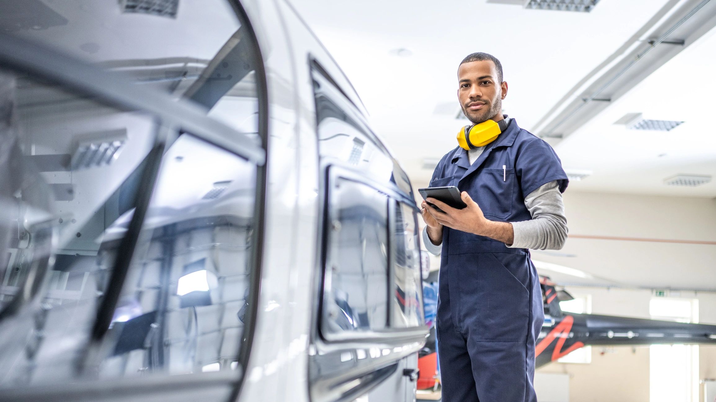 Technician running car diagnostics and module coding with a diagnostic tablet