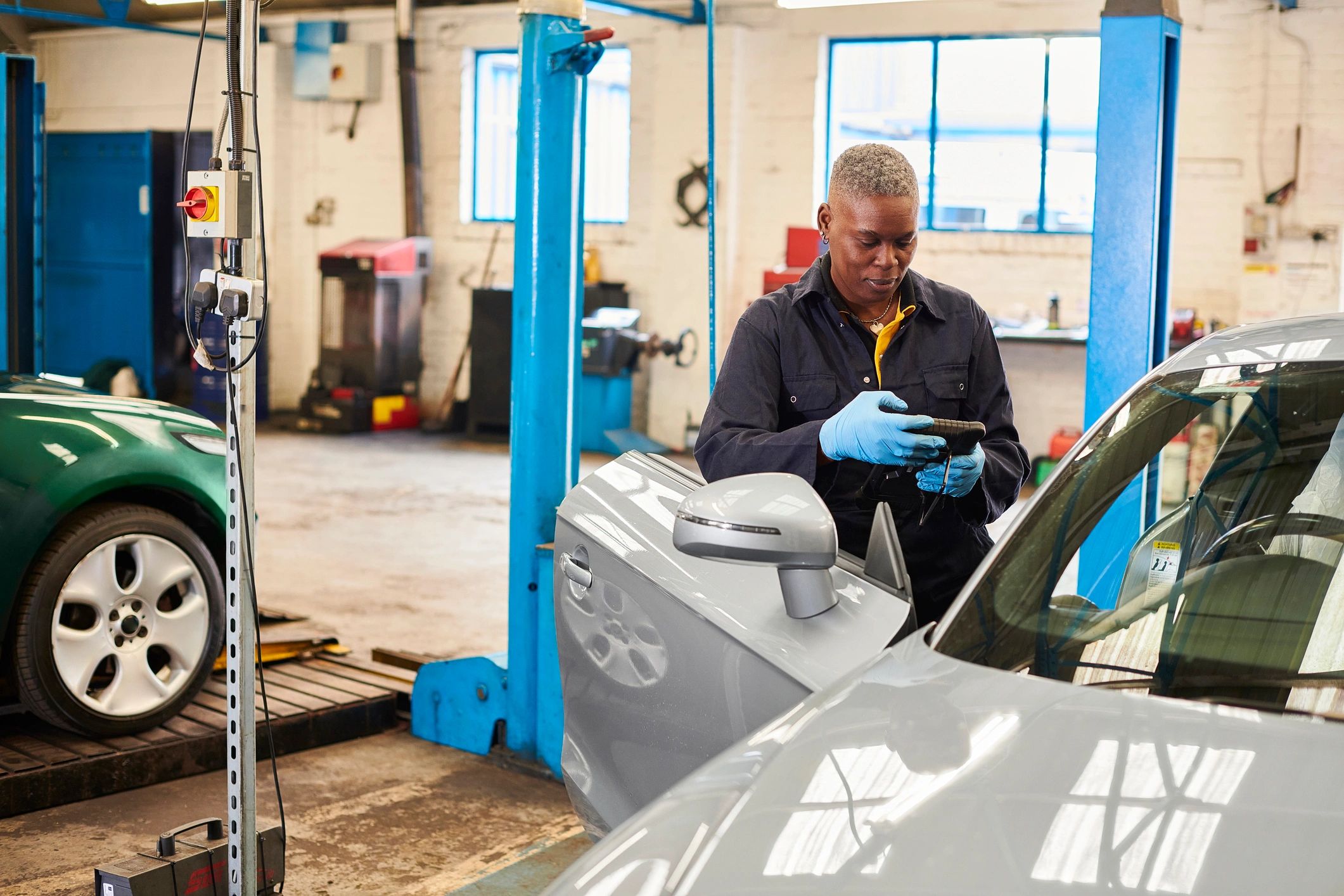 Auto technician performing OBD diagnostics and ECU coding