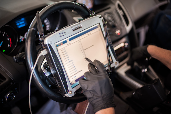 About automobile computer diagnosis. car mechanic repairer looks for engine failure
